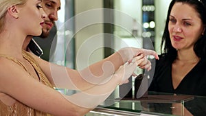 Jewelry store Choice of gold jewelry in the jewelry store, Betrothed girl and the guy in the jewelry store choosing