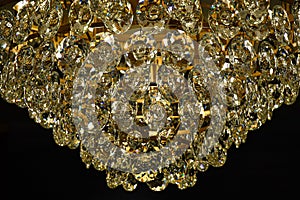 Jewelry style shiny glass texture closeup. Sparkle crystal hangings of luxury chandelier on black background. Vintage diamond lamp