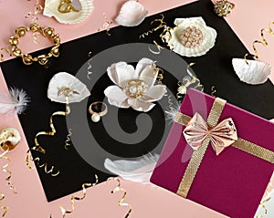 White pearl gold jewelry and gift box with pink roses petal seashell  still life pink and black background