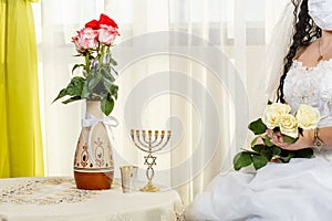 A Jewish bride, a fragment of her face before a chuppa ceremony during a pandemic, wearing a medical mask and a bouquet