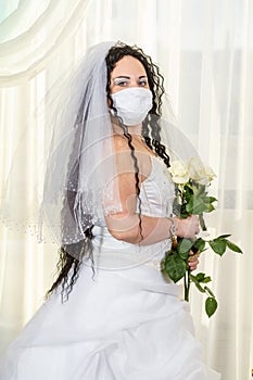 A Jewish bride in a synagogue before a chuppa ceremony during a pandemic, wearing a medical mask and a bouquet of