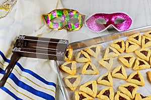 Jewish cookies Haman ears for Purim with mask, tallit and noisemaker