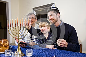 Jewish family lighting Chanukah menorah photo