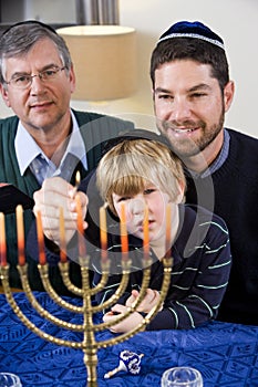 Jewish family lighting Chanukah menorah photo