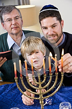 Jewish family lighting Chanukah menorah photo