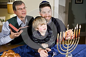 Jewish family lighting Hanukkah menorah photo