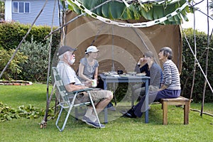 Jewish Family Sitting in a Sukkah on Sukkoth Feast of Tabernacle photo
