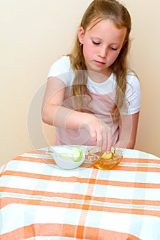 Jewish girl dipping apple slices into honey on Rosh HaShanah.