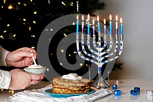 For a Jewish holiday dinner Hanukkah menorah is lit and crispy potato latkes are served.