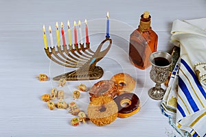 Jewish holiday hannukah symbols - menorah, doughnuts, chockolate coins and wooden dreidels.