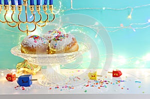 jewish holiday Hanukkah background of menorah (traditional candelabra), doughnut and candles. Spinning tops with letters