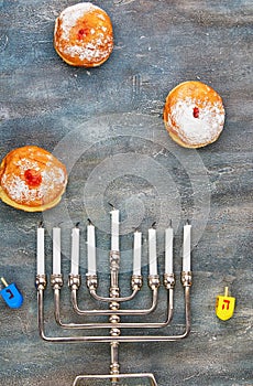 Jewish holiday Hanukkah background. A traditional dish is sweet donuts. Hanukkah table setting a candlestick with candles and