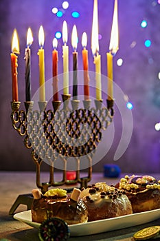 Jewish holiday Hanukkah background. A traditional dish is sweet donuts. Hanukkah table setting a candlestick with candles and