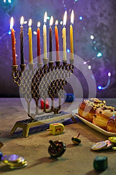 Jewish holiday Hanukkah background. A traditional dish is sweet donuts. Hanukkah table setting a candlestick with candles and