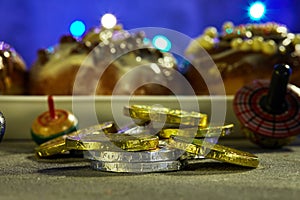 Jewish holiday Hanukkah background. A traditional dish is sweet donuts. spinning tops on a blue background and Hanukkah money-gelt