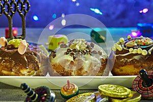 Jewish holiday Hanukkah background. A traditional dish is sweet donuts. spinning tops on a blue background and Hanukkah money-gelt