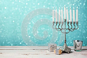 Jewish holiday Hanukkah celebration with menorah, dreidel and gifts on wooden table photo