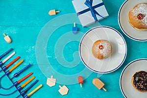 Jewish holiday Hanukkah concept with menorah, sufganiyot, gift b