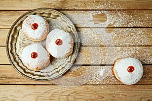 Jewish holiday Hanukkah concept with traditional donuts sufganiyah on wooden table background