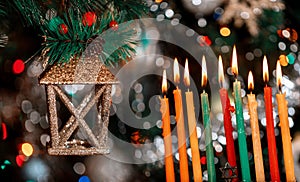 Menorah with burning candles for Hanukkah on sparkle background with defocused lights. Jewish holiday