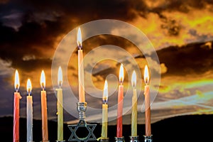 Jewish holiday Hanukkah with menorah traditional burning candles beautiful sunset photo