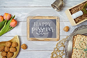 Jewish holiday Passover background with matzo, seder plate, wine and chalkboard frame on wooden table