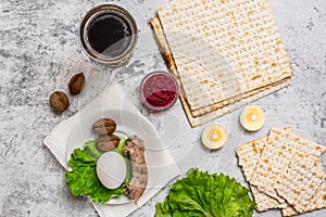 Jewish holiday Passover background with wine, matza and seder plate on grey. Top view. With copy space