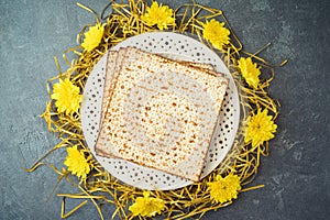 Jewish holiday Passover concept with matzah, seder plate and golden decorations on dark background