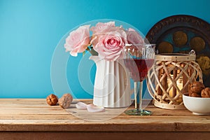 Jewish holiday Passover concept with wine glass, matzah and flowers on wooden table