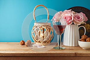 Jewish holiday Passover concept with wine glass, matzah and flowers on wooden table