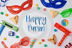 Jewish holiday Purim concept with hamantaschen cookies, carnival mask and noisemaker on white background. photo