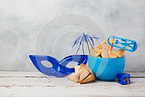 Jewish holiday Purim concept with hamantaschen cookies or hamans ears and carnival mask