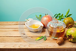 Jewish holiday Rosh Hashana background with honey jar, apple and pomegranate on wooden table