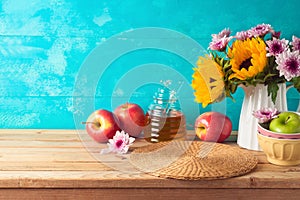 Jewish holiday Rosh Hashana background with honey jar, apples and sunflowers on wooden table. Kitchen counter with copy space for