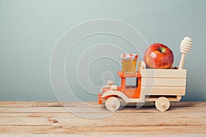 Jewish holiday Rosh Hashana background with toy truck, honey and apples
