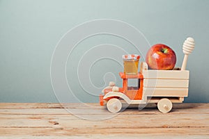 Jewish holiday Rosh Hashana background with toy truck, honey and apples photo