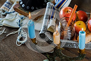 Jewish Holiday Rosh hashanah honey and apples with pomegranate and candles on Prayer Shawl Tallit