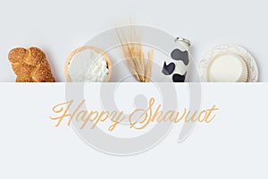 Jewish holiday Shavuot banner design with milk bottle, cheese and bread on white background. Top view from above