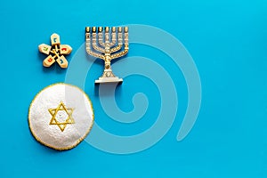 Jewish Kippah Yarmulkes hats with menorah on blue wooden table. Top view, copy space
