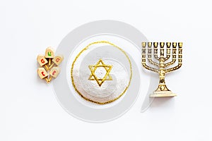Jewish Kippah Yarmulkes hats with menorah on white table. Top view