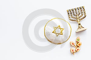 Jewish Kippah Yarmulkes hats with menorah on white table. Top view, copy space