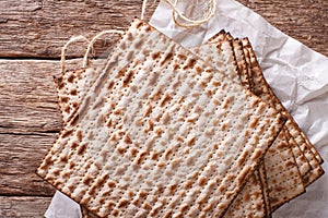 Jewish kosher matzo for Passover closeup on a wooden table. horizontal top view