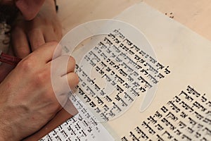 Jewish man with beard writing on a parchment scroll. Photo taken on: December 30th,2015