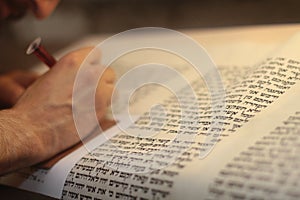 Jewish man with beard writing on a parchment scroll. Photo taken on: December 30th,2015