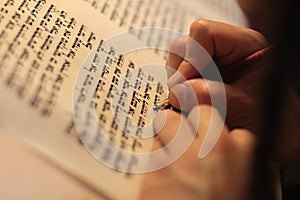 Jewish man with beard writing on a parchment scroll. Photo taken on: December 30th,2015