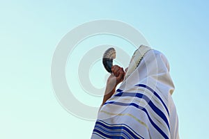 Jewish man blowing the Shofar (horn) of Rosh Hashanah (New Year)