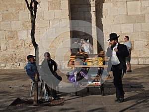 Jewish man on cel phone and bread vendor in Jerusalem