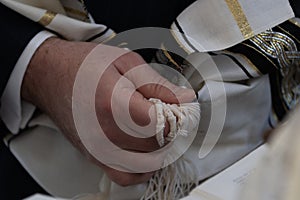 Holding tzitzit around the hand during Jewish prayer photo