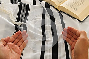 Jewish man hands next to Prayer book, praying, next to tallit. Jewish traditional symbols. Rosh hashanah jewish New Year holiday