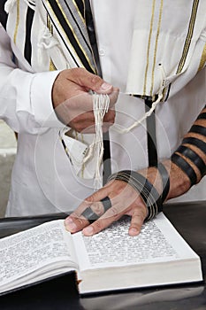 An jewish man is reading his bible and praying